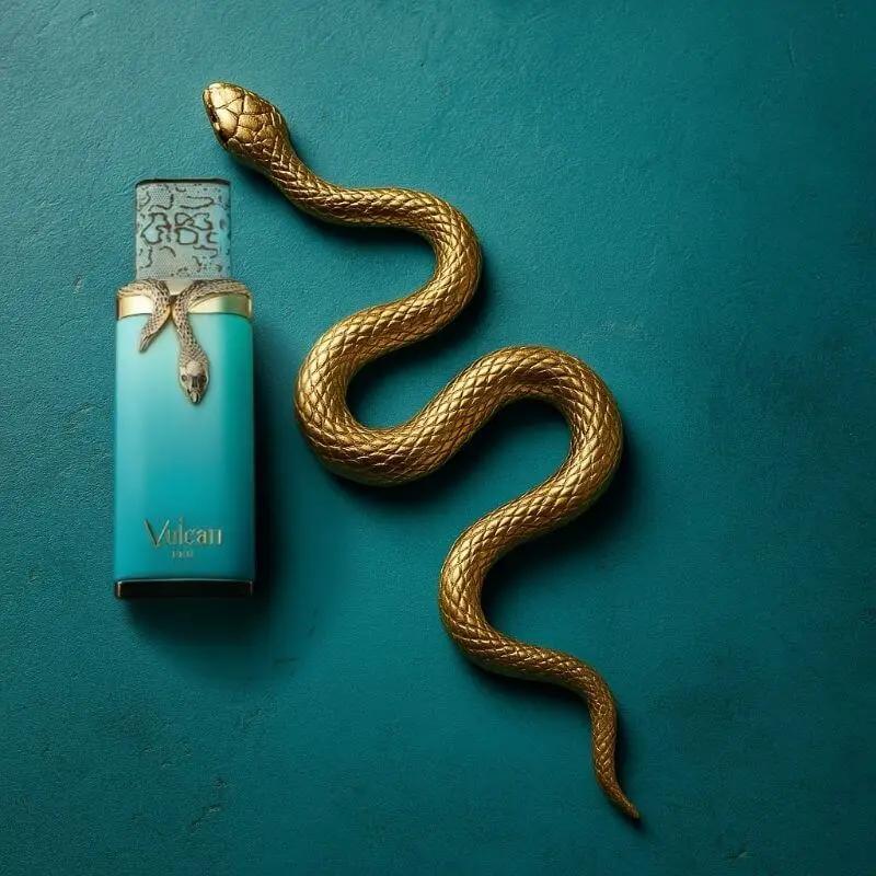 Parfum Vulcan de French Avenue en flacon turquoise orné d’un serpent doré, présenté sur un fond bleu élégant